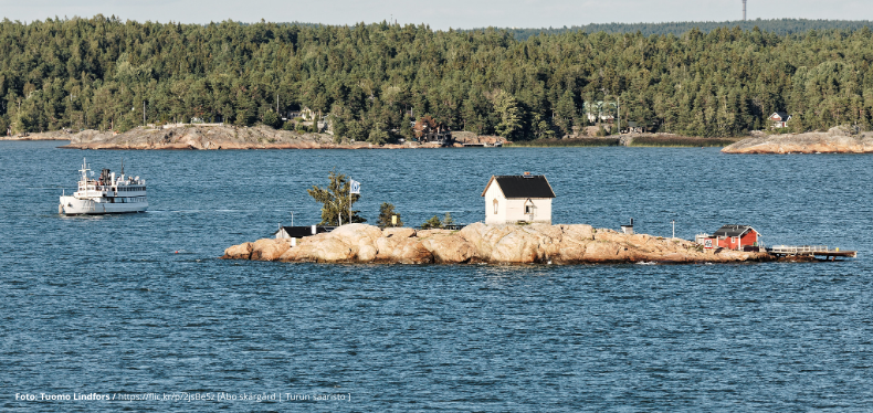 Foto fråb skärgården. Visar en ö i Åbo skärgård med ett fartyg vid sidan.